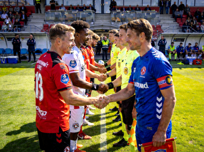 Gambar tim sepak bola sedang berjabat tangan sebelum memulai pertandingan